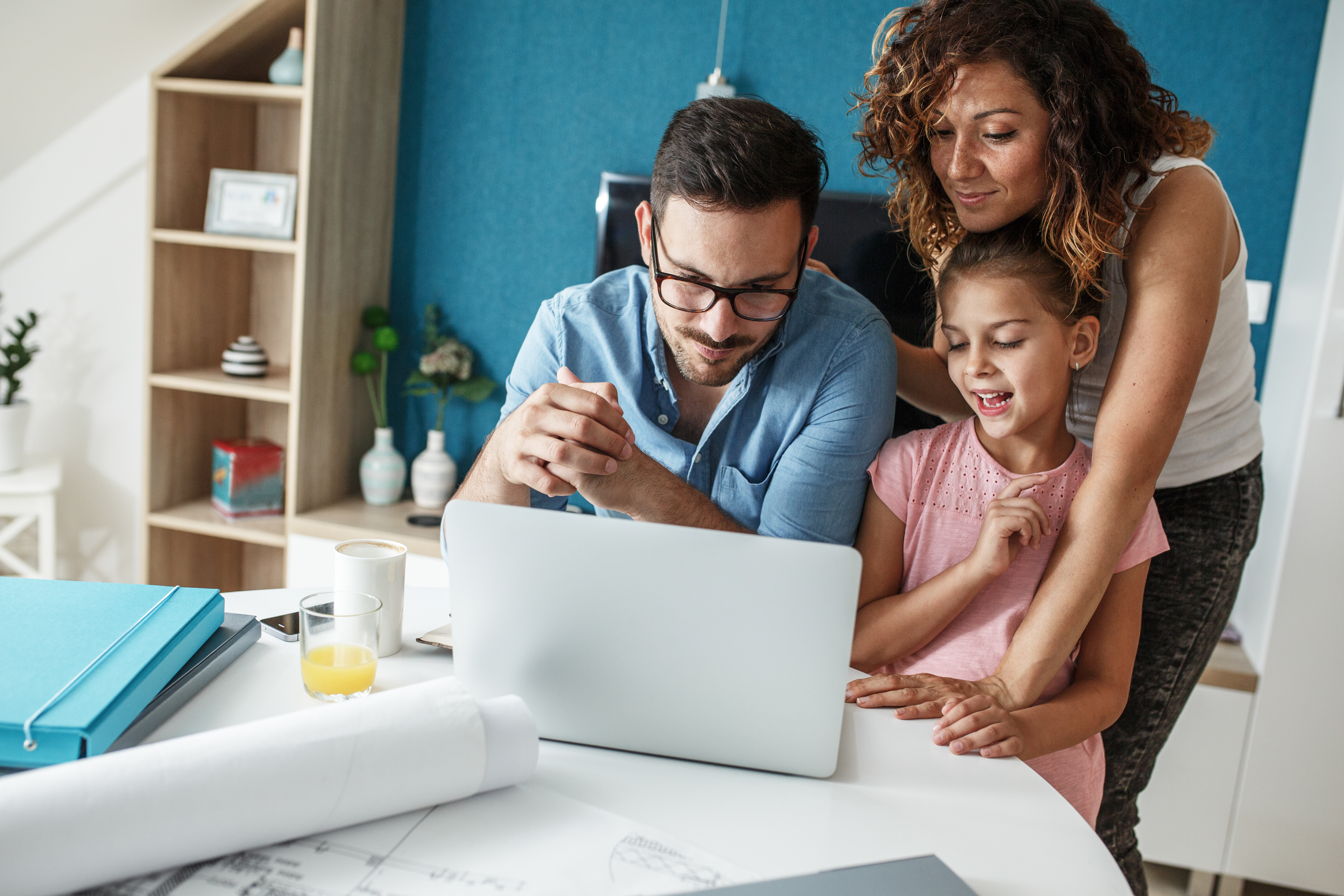 Middle age businessman working at home.Wife and daughter  stands beside and support him.