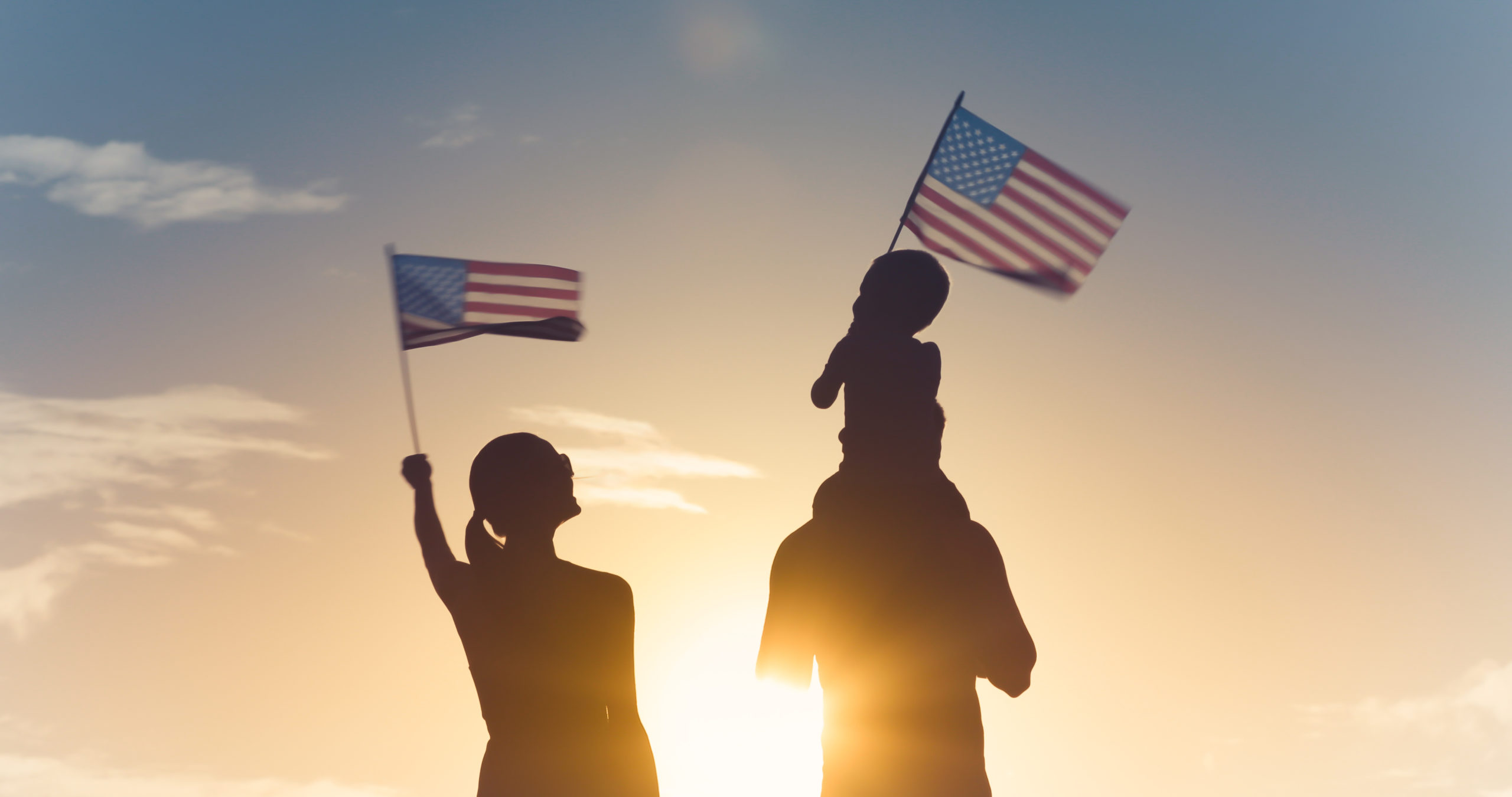 Patriotic man, woman, and child waving American flags in the air. Patriotic man, woman, and child waving American flags in the air.