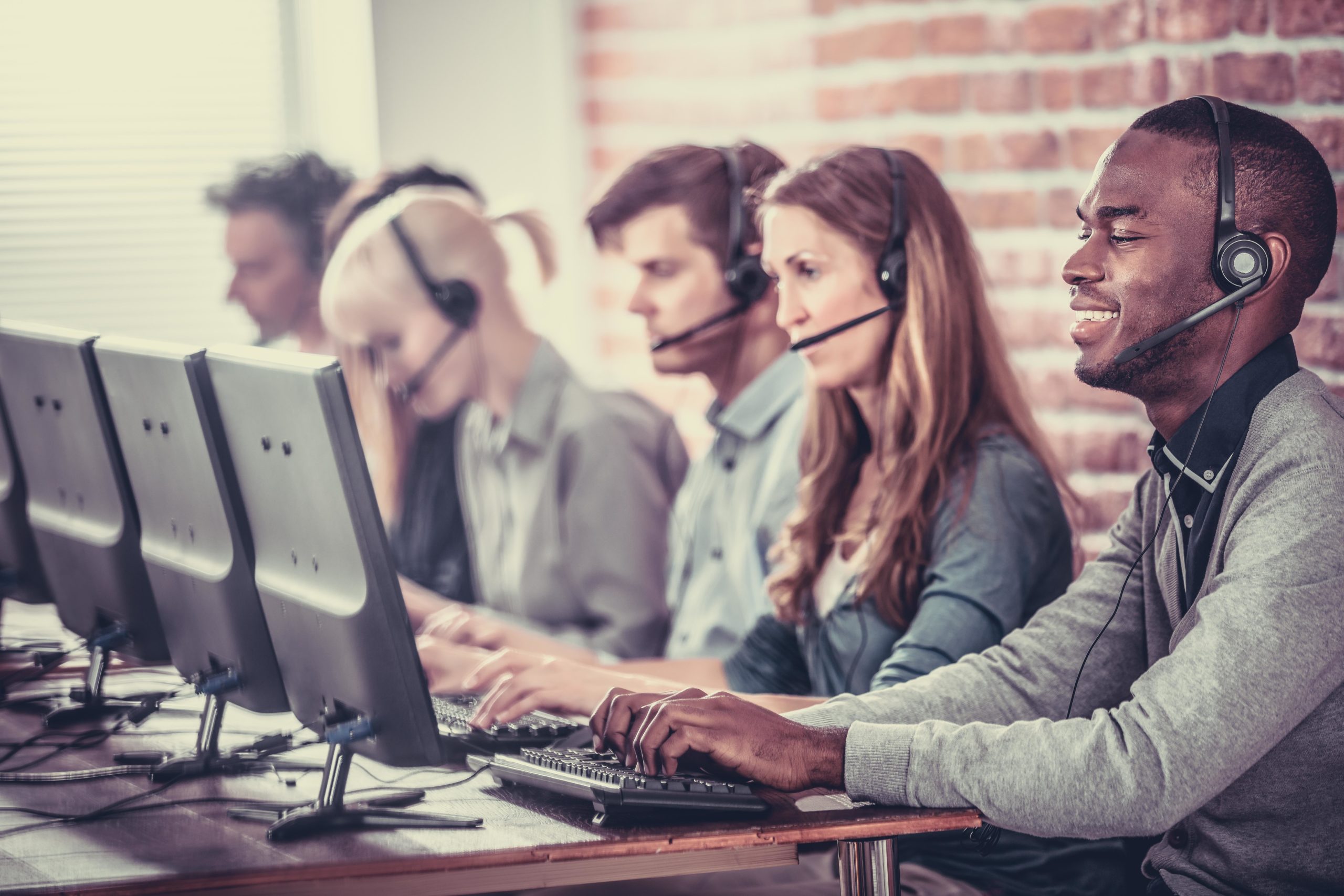 Young Call Center Team Talking With Customers