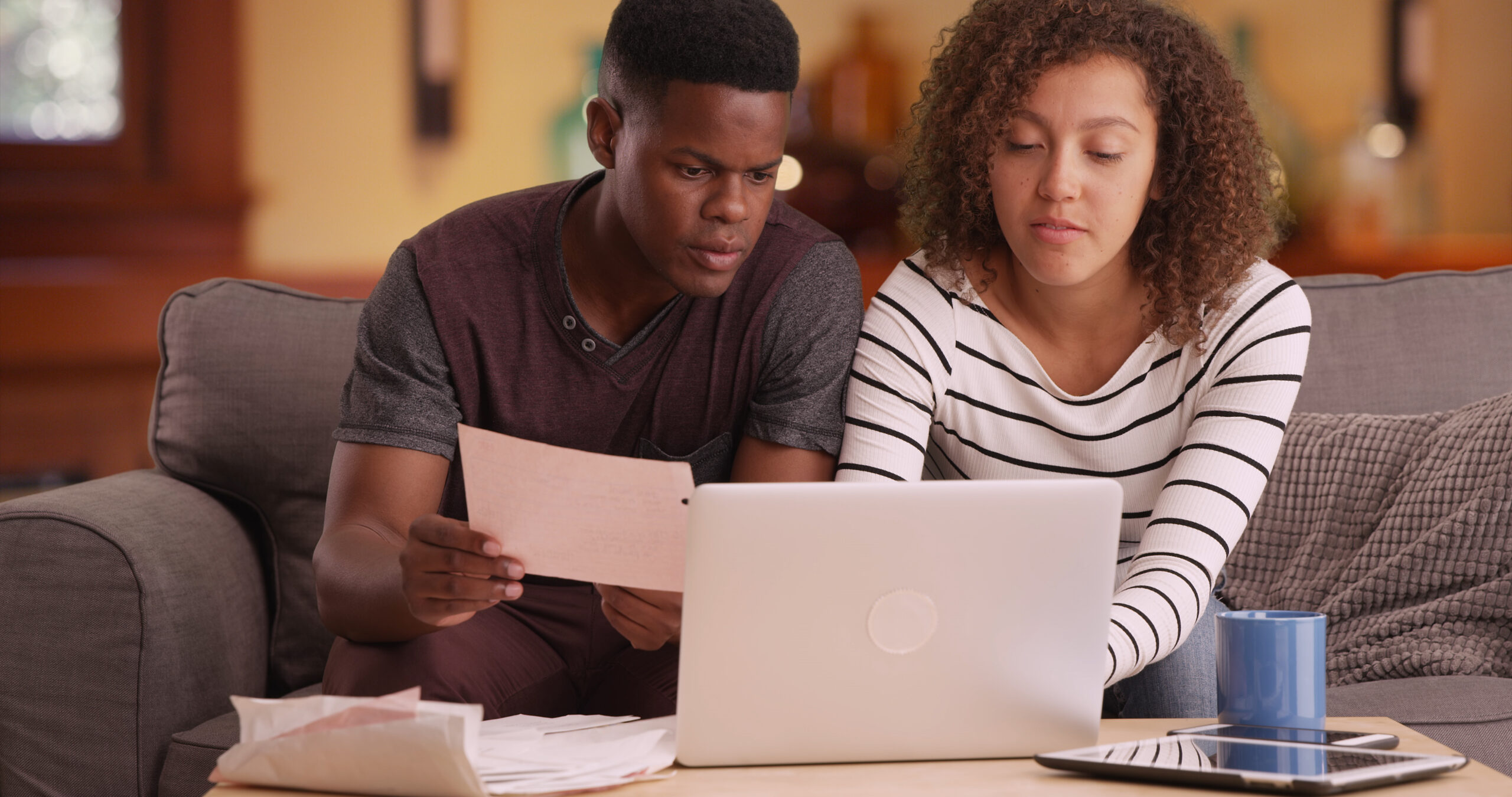 African American couple pays their bills on their laptop